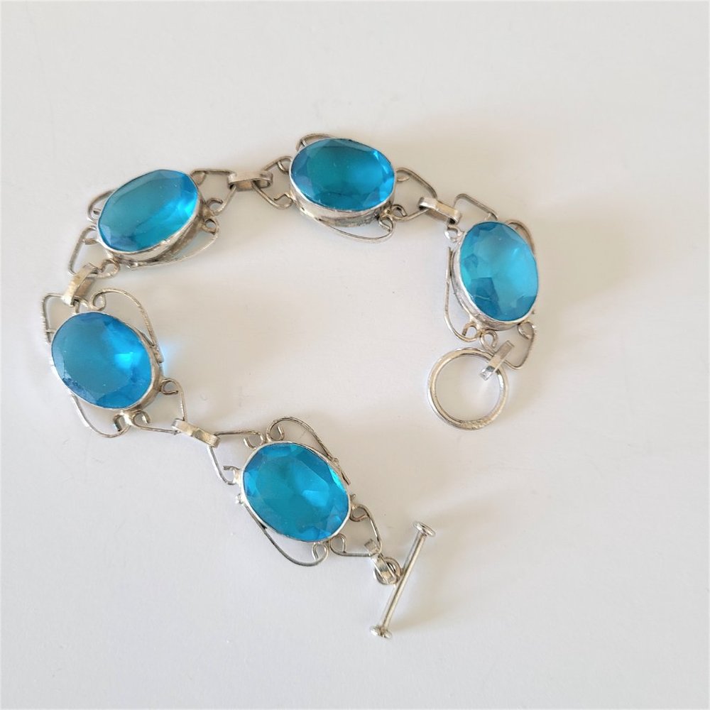 Silver color metal and blue stones bracelet.